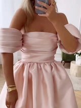 close-up of a woman in a pink off-the-shoulder dress, showing the bodice and sleeve detail