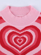 Close-up of the mock neck and heart pattern on a pink and red striped knit top.