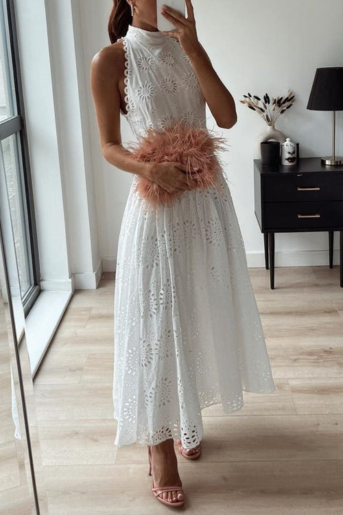 Woman wearing a white eyelet midi dress with a pink feather clutch and pink heels