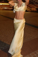Close-up of a woman's toned abs in a beige satin crop top.