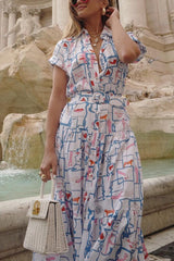 Close-up of a woman's torso wearing a printed shirt dress with a collared neckline and gold necklaces.