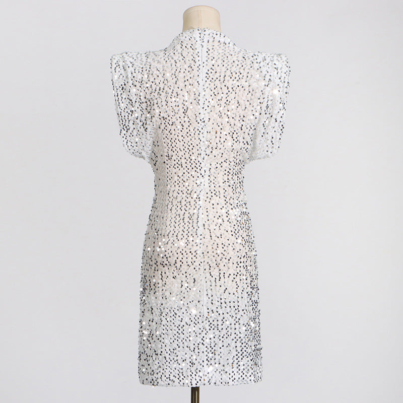 The back of a white sequined dress with cap sleeves and a high neckline on a mannequin.