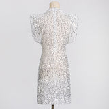 The back of a white sequined dress with cap sleeves and a high neckline on a mannequin.