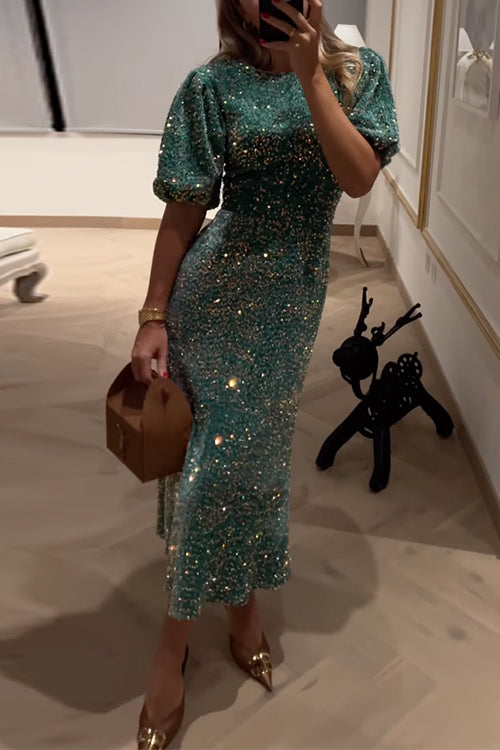 Close-up of a woman's torso in a green sequined midi dress with puff sleeves, showing the sparkle of the sequins.