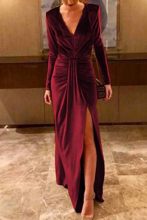 woman in a burgundy velvet dress with a high slit
