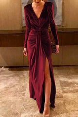 woman in a burgundy velvet dress with a high slit