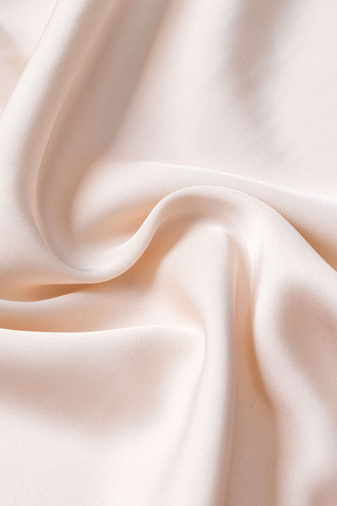 Close-up of draped cream satin fabric.
