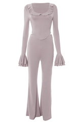 A pink two-piece set with a ruffled neckline, long flared sleeves, and flare pants, displayed flat.