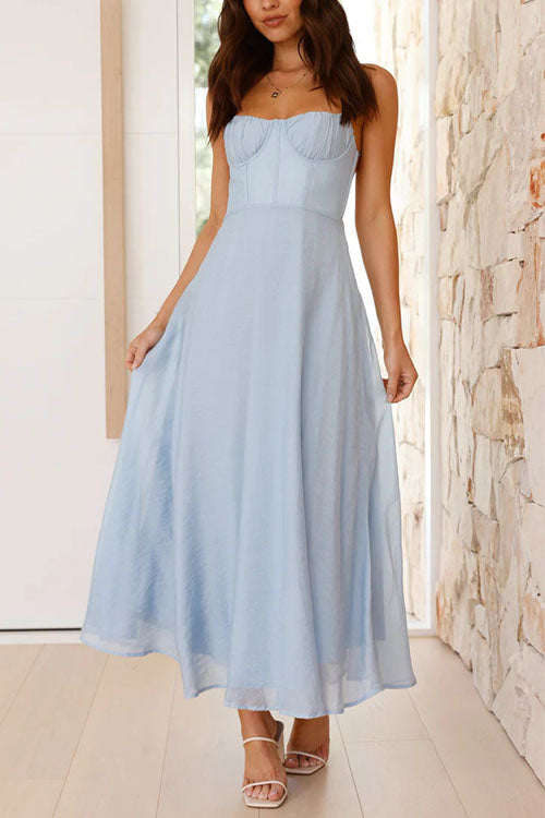 A woman modeling a light blue midi dress with a sweetheart neckline and spaghetti straps.