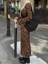 Side view of a woman in a brown floral maxi dress and black boots.
