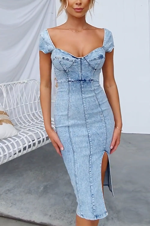 woman wearing a light blue denim sheath dress with a sweetheart neckline, cap sleeves, and a high slit