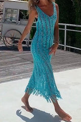 Woman in a blue crochet knit midi dress on a wooden deck