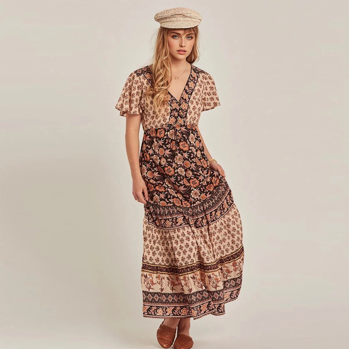 woman wearing a floral print maxi dress and a straw hat