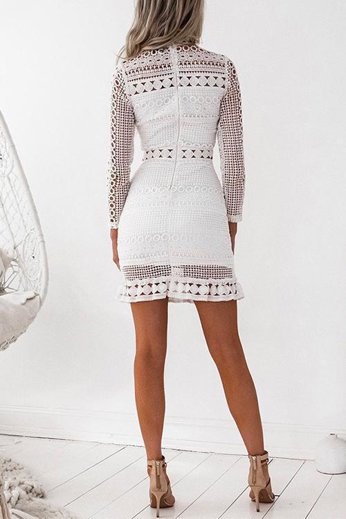 Back view of a woman in a white lace bodycon dress with long sleeves and a ruffle hem.