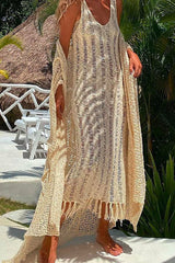Woman wearing a beige crochet knit maxi dress with fringe hem and a matching shawl