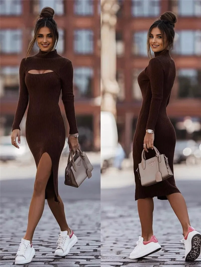 Woman in a brown ribbed knit dress with a cut-out and high slit, wearing white sneakers with pink accents and carrying a beige handbag.