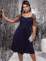 woman in navy blue dress holding a silver clutch