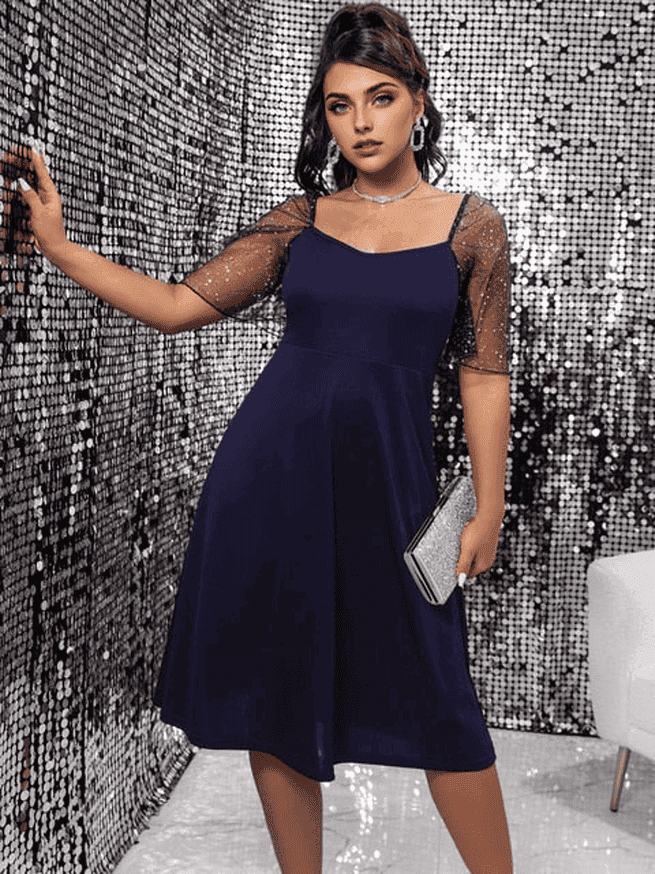 woman in navy blue dress holding a silver clutch