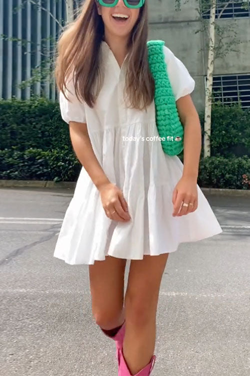 Close-up of a woman wearing a white tiered dress, bright pink cowboy boots, and a green crochet bag.
