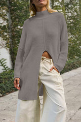 woman wearing a gray long knit sweater with a high slit