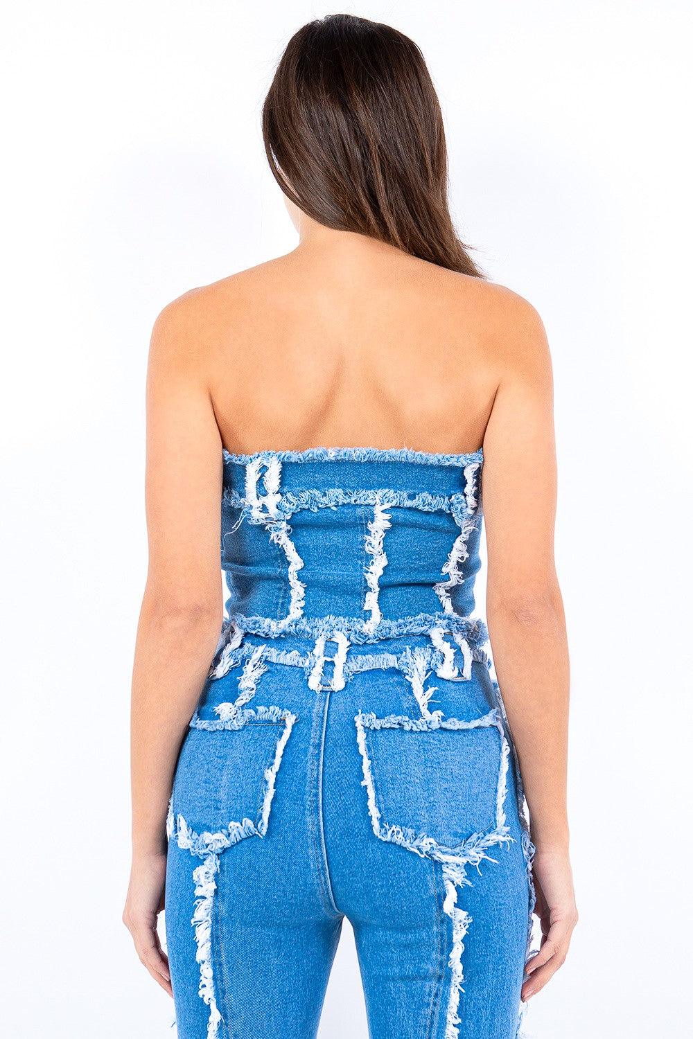 back view of a woman wearing a blue denim strapless top with frayed detailing