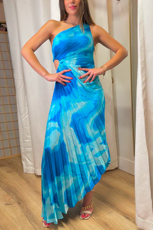 woman posing in a blue and white tie-dye pleated one-shoulder maxi dress with a cut-out