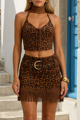 A woman wearing a leopard print halter top and matching mini skirt with fringe detail.