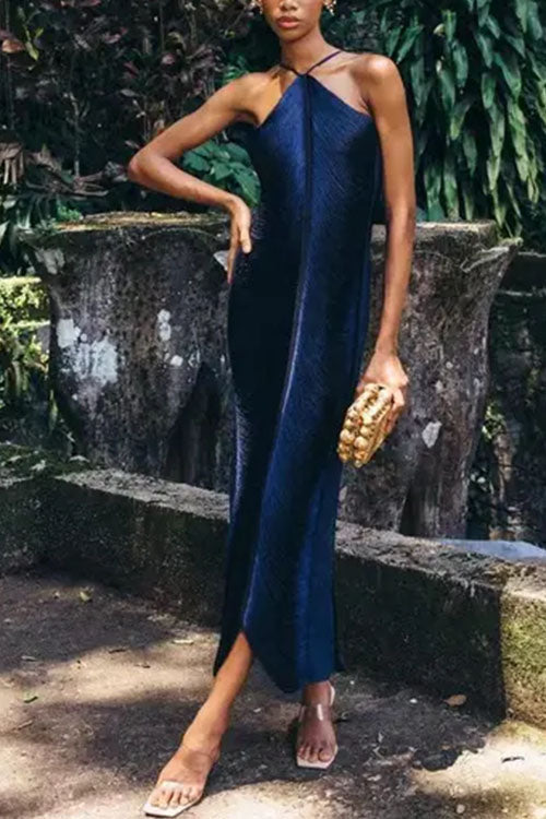 Woman wearing a navy blue ruched halter neck maxi dress