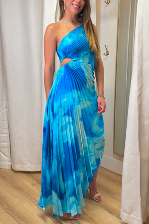 woman in a blue and white tie-dye pleated one-shoulder maxi dress with a cut-out detail