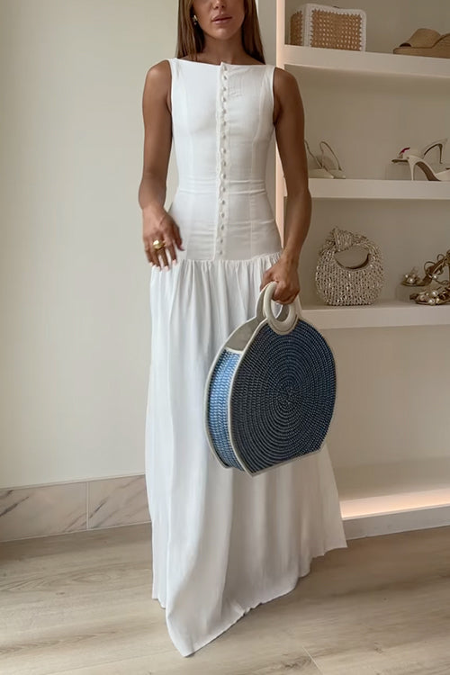 Woman in a white maxi dress holding a round blue and white straw bag