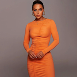Woman in an orange ruched long-sleeve dress