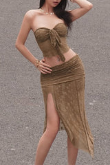A woman wearing a brown two-piece outfit with a tube top and a ruched skirt.