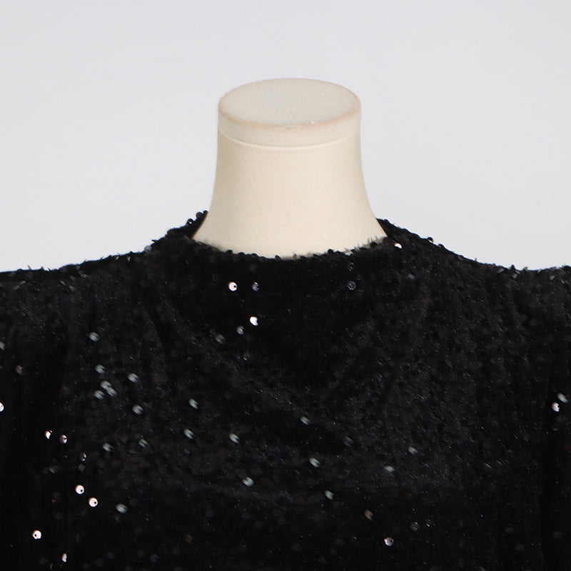 close-up of the high neckline and padded shoulders of a black sequined dress
