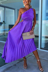 A woman in a purple one-shoulder pleated dress with a cut-out detail and a beige clutch.