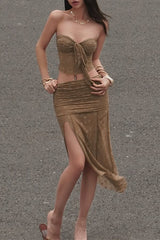 A woman in a brown tube top and a matching brown skirt with a high slit.