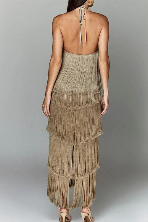 Back view of a woman wearing a gold, tiered fringe halter dress