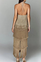 Back view of a woman wearing a gold, tiered fringe halter dress