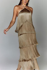 Woman in a gold, tiered fringe halter dress posing dynamically