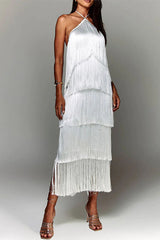 Woman in a white, tiered fringe halter dress with strappy heels
