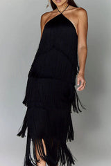 Woman in a black, tiered fringe halter dress with her hand on her hip