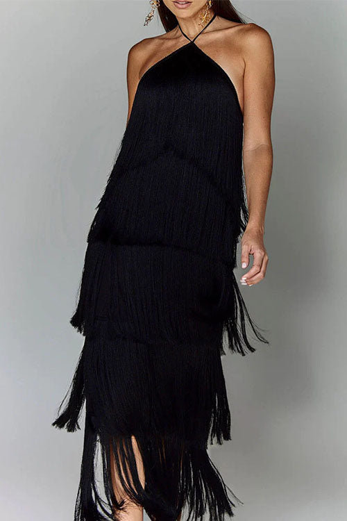 Woman in a black, tiered fringe halter dress with her hand on her hip