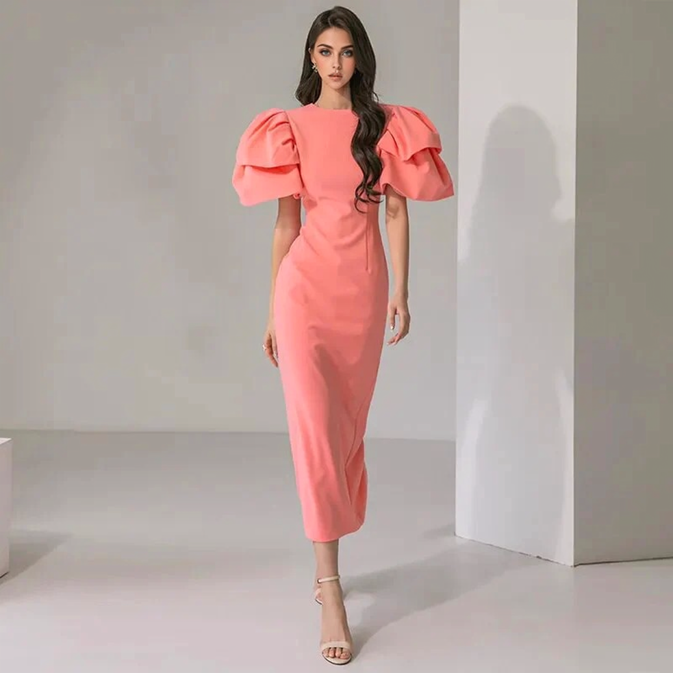 woman in a coral pink midi dress with dramatic puff sleeves walking forward