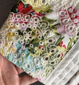 A hand holding the side of the corset top, showing the boning and hook-and-eye closure.