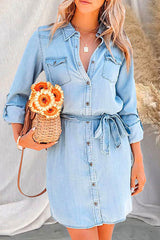 Woman wearing a light blue denim shirt dress with a basket purse