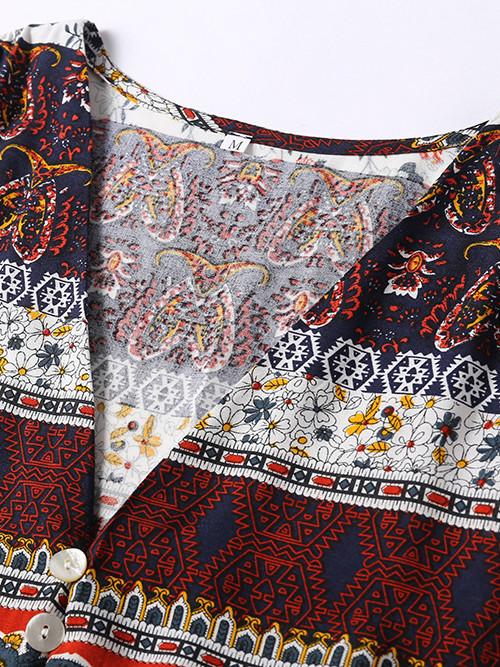 Close-up of the neckline and bodice of a dress with a paisley and floral print in navy, red, and white.