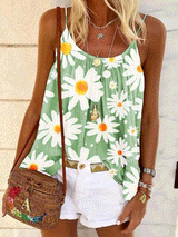 Woman wearing a green tank top with a white daisy print, white shorts, and a woven crossbody bag.