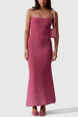 Model wearing a pink and red striped strapless maxi dress with a pink shoulder bag and pink heeled sandals