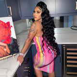 Woman wearing a pink, yellow, and blue striped bodycon midi dress with spaghetti straps, posing in a kitchen.