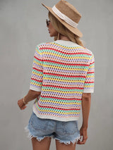 Back view of a woman in a multicolor striped crochet knit top, light blue distressed denim shorts, and a straw hat.