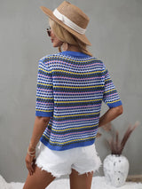 Back view of a woman in a blue and multicolor striped crochet knit top, white distressed denim shorts, and a straw hat.